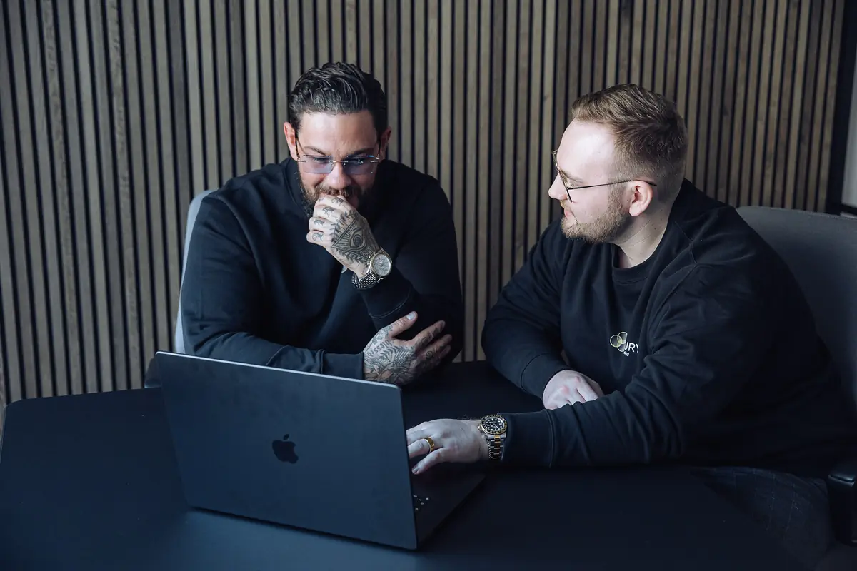 Tim Wöhler und Sandro Heine im Gespräch am Laptop