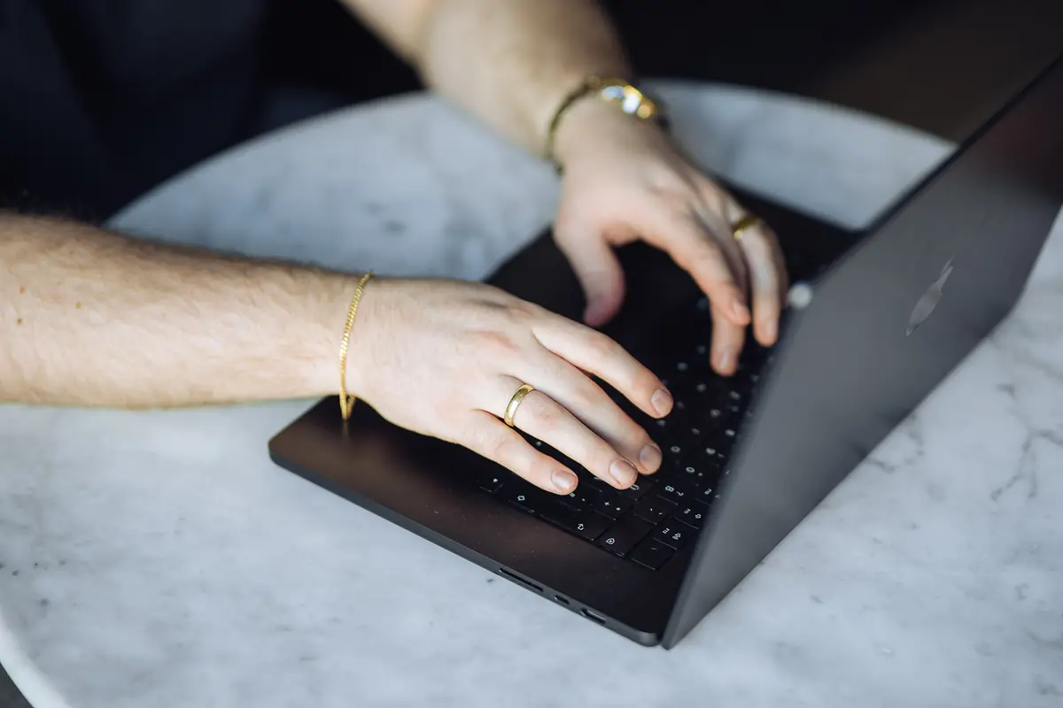 Hände an der Tastatur eines Laptops