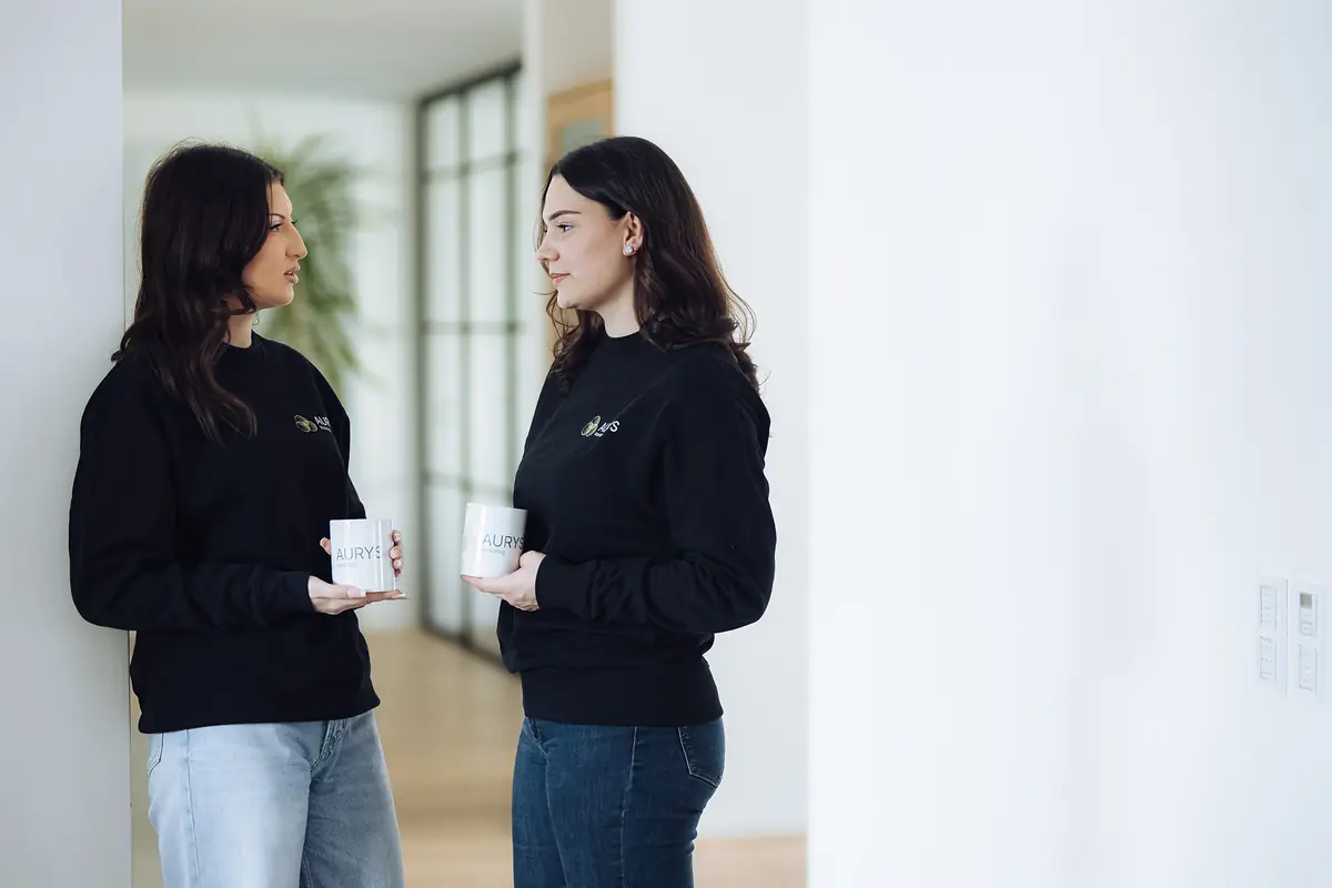 Zwei Kolleginnen im Gespräch mit Kaffee